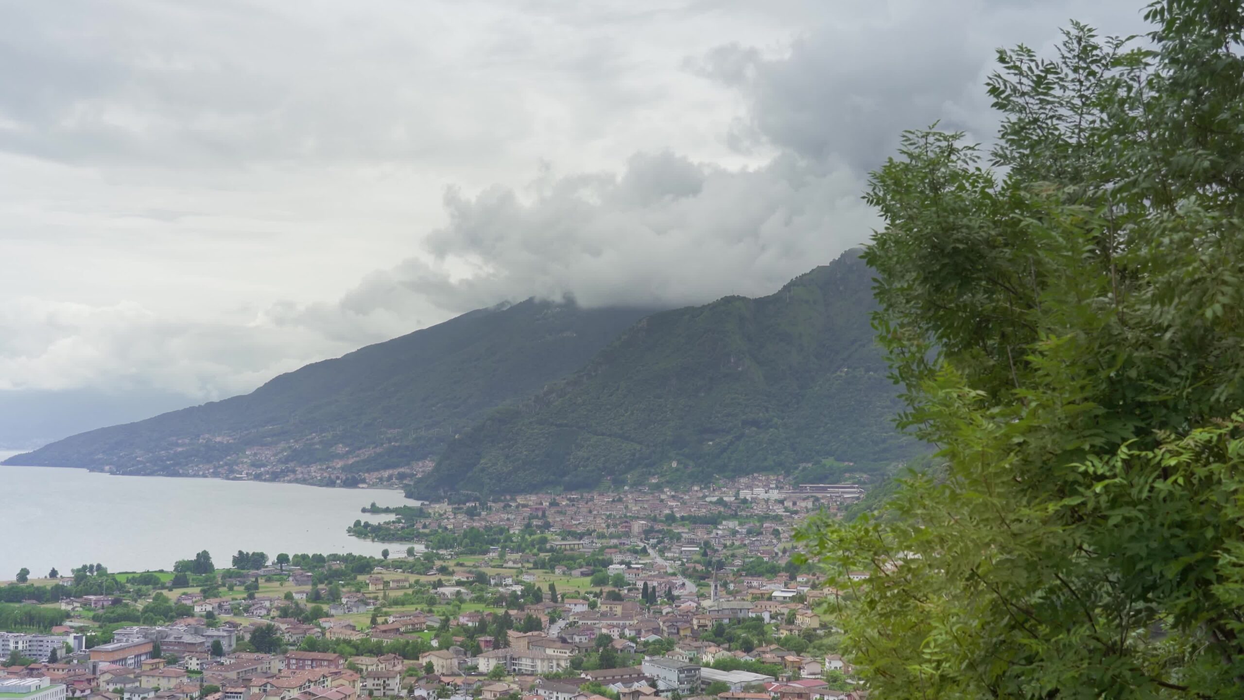 Comune di Gravedona sopra le montagne verdi con tante nuvole