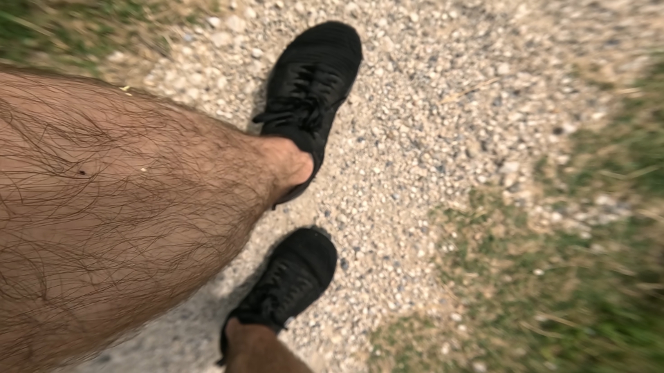 Feet with shoes walking on a dirt ground