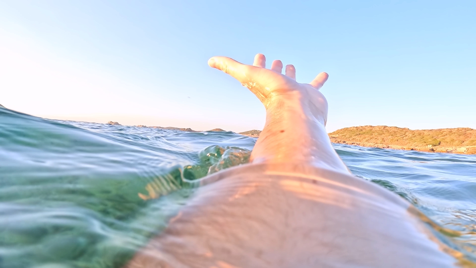 Elongated hand drowns in the green sea