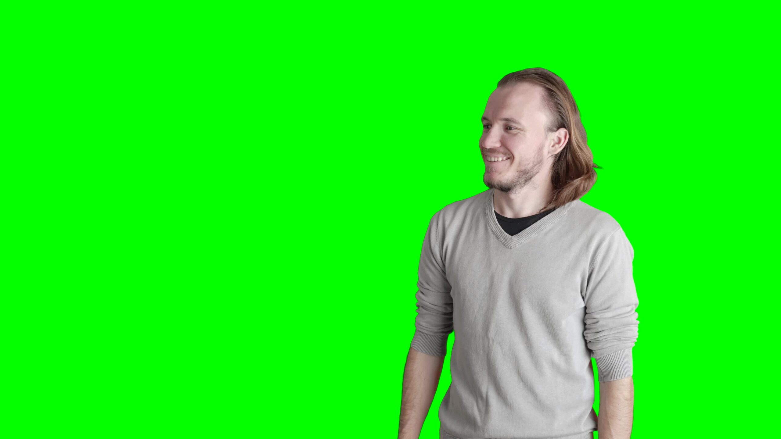 Man smiles looking at green screen