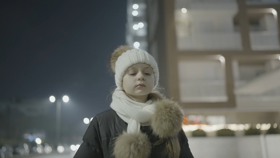 Bambina in Città di Sera: Un Momento d’Inverno