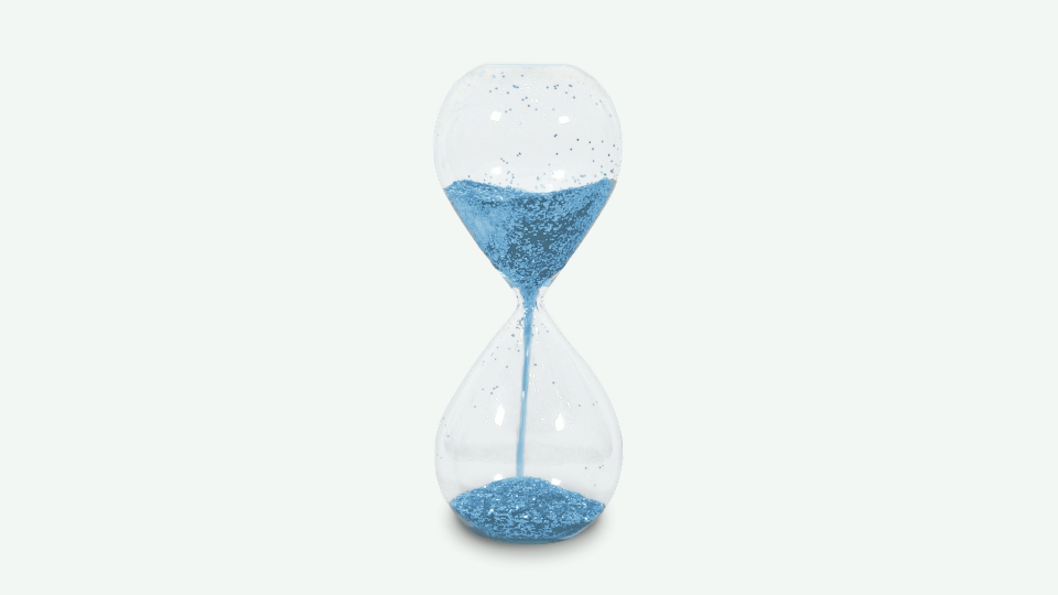 Hourglass with blue sand on gray background