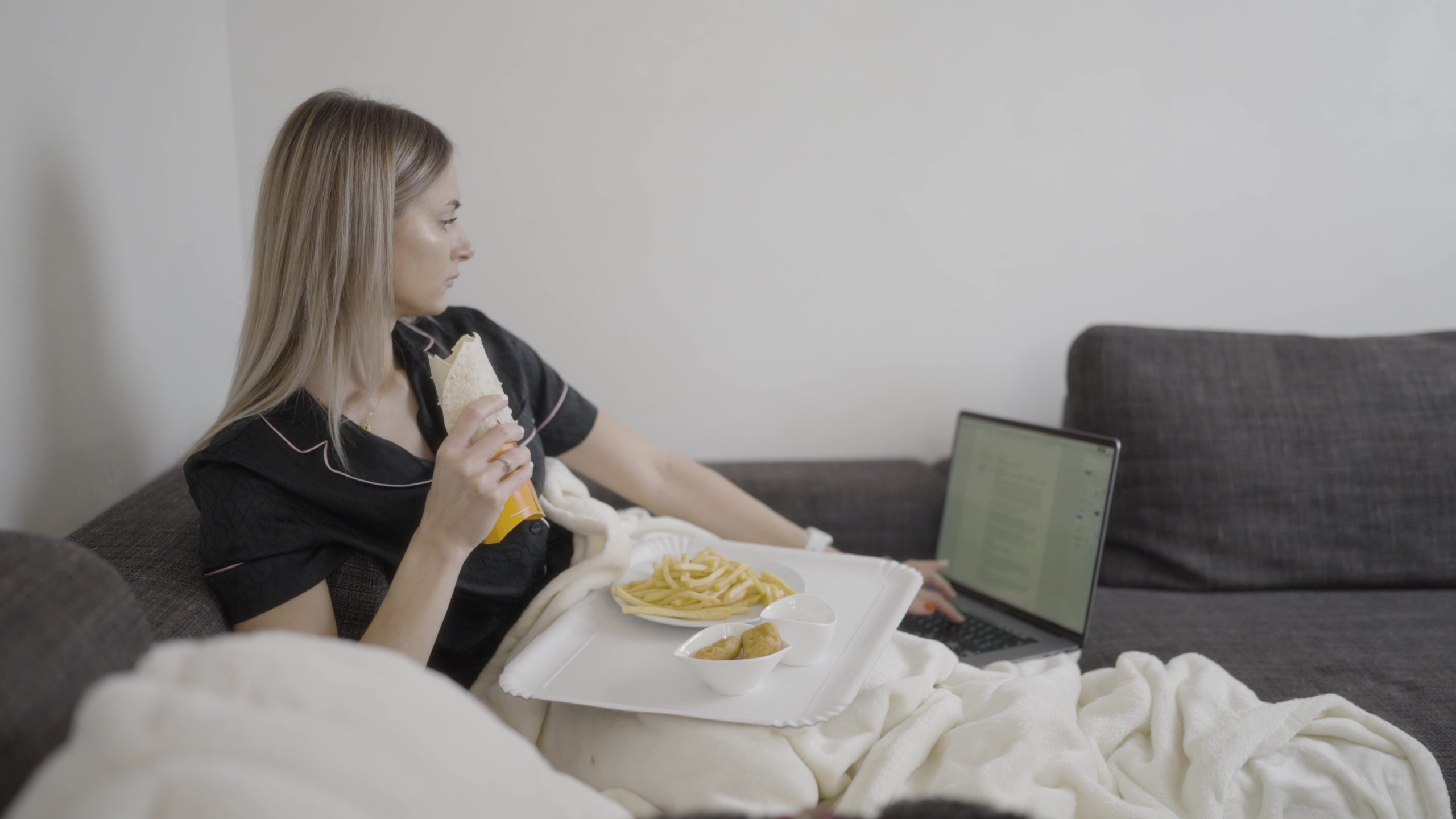 Woman is eating while working on the computer