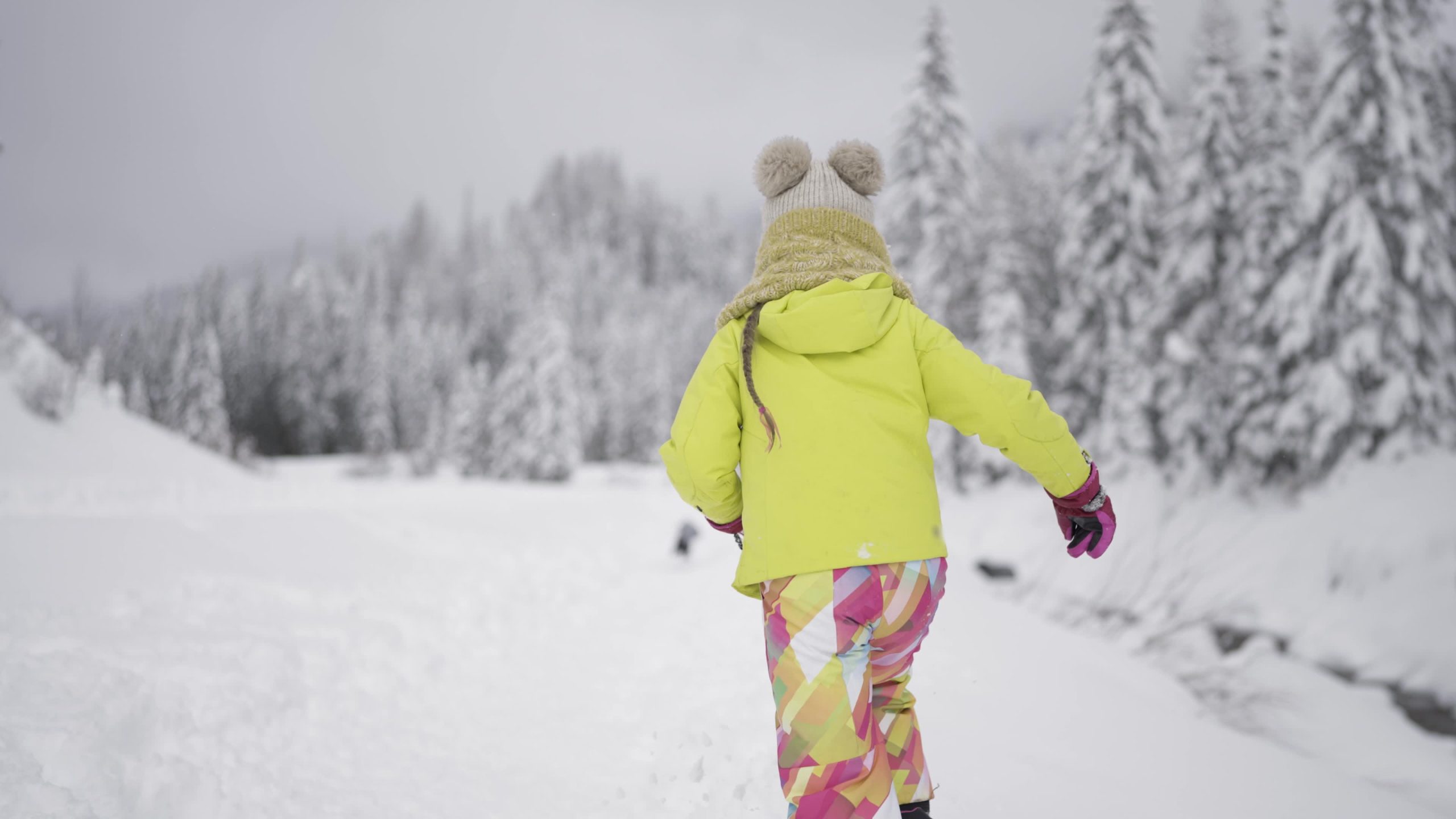 Little girl runs in the snow in winter