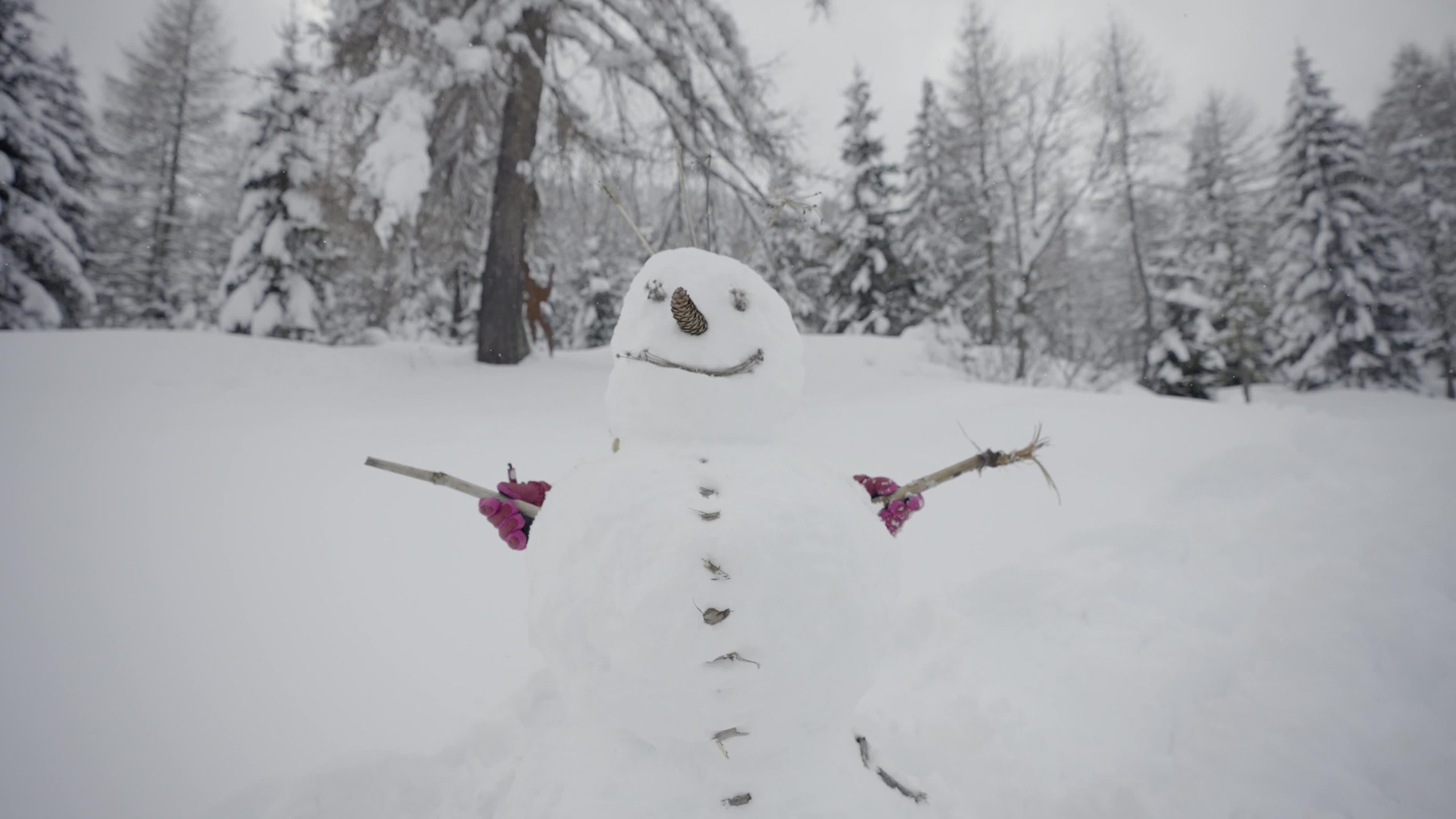 Bambina muove le braccia del pupazzo di neve