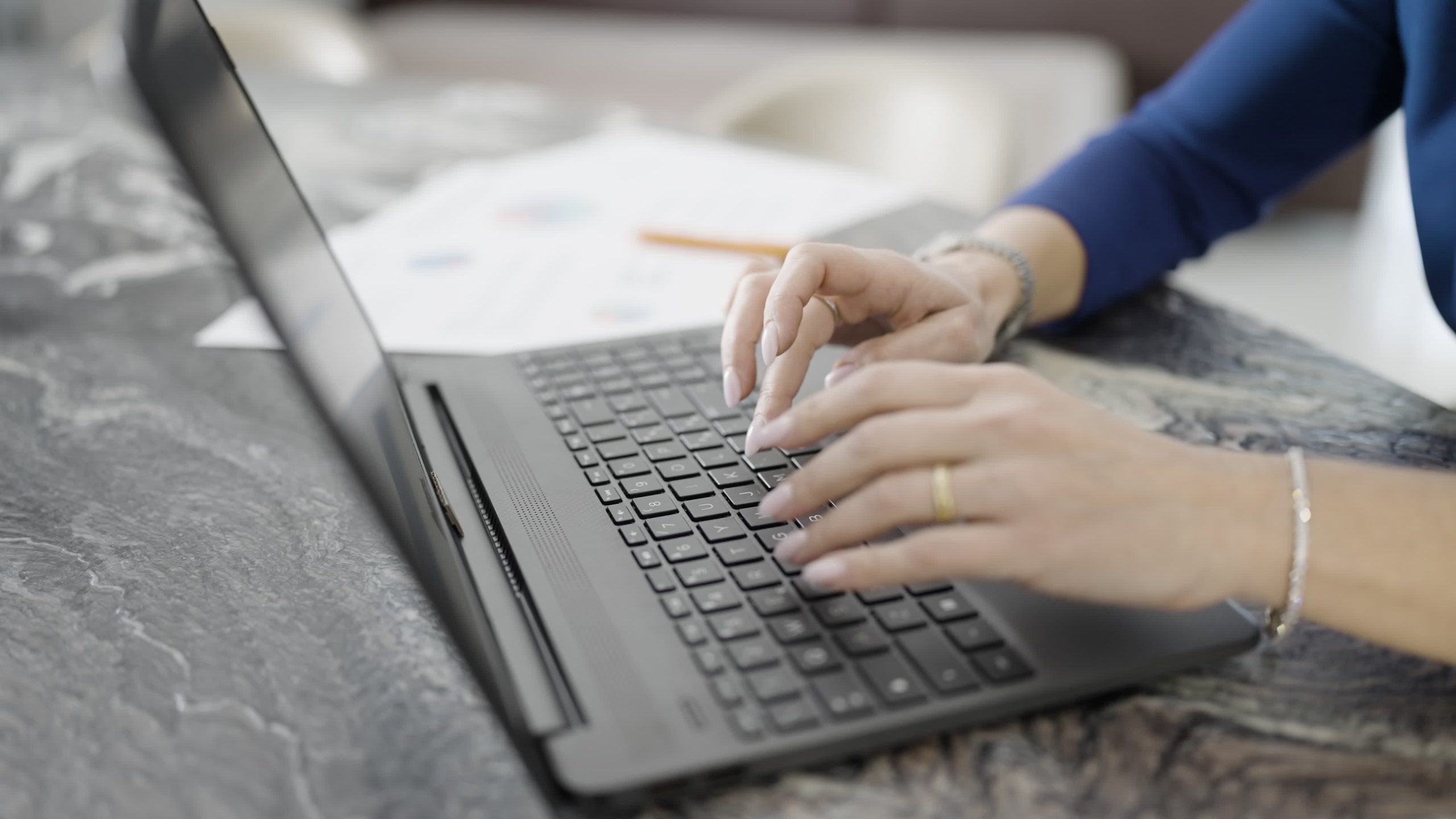 Woman’s hands type on laptop keyboard