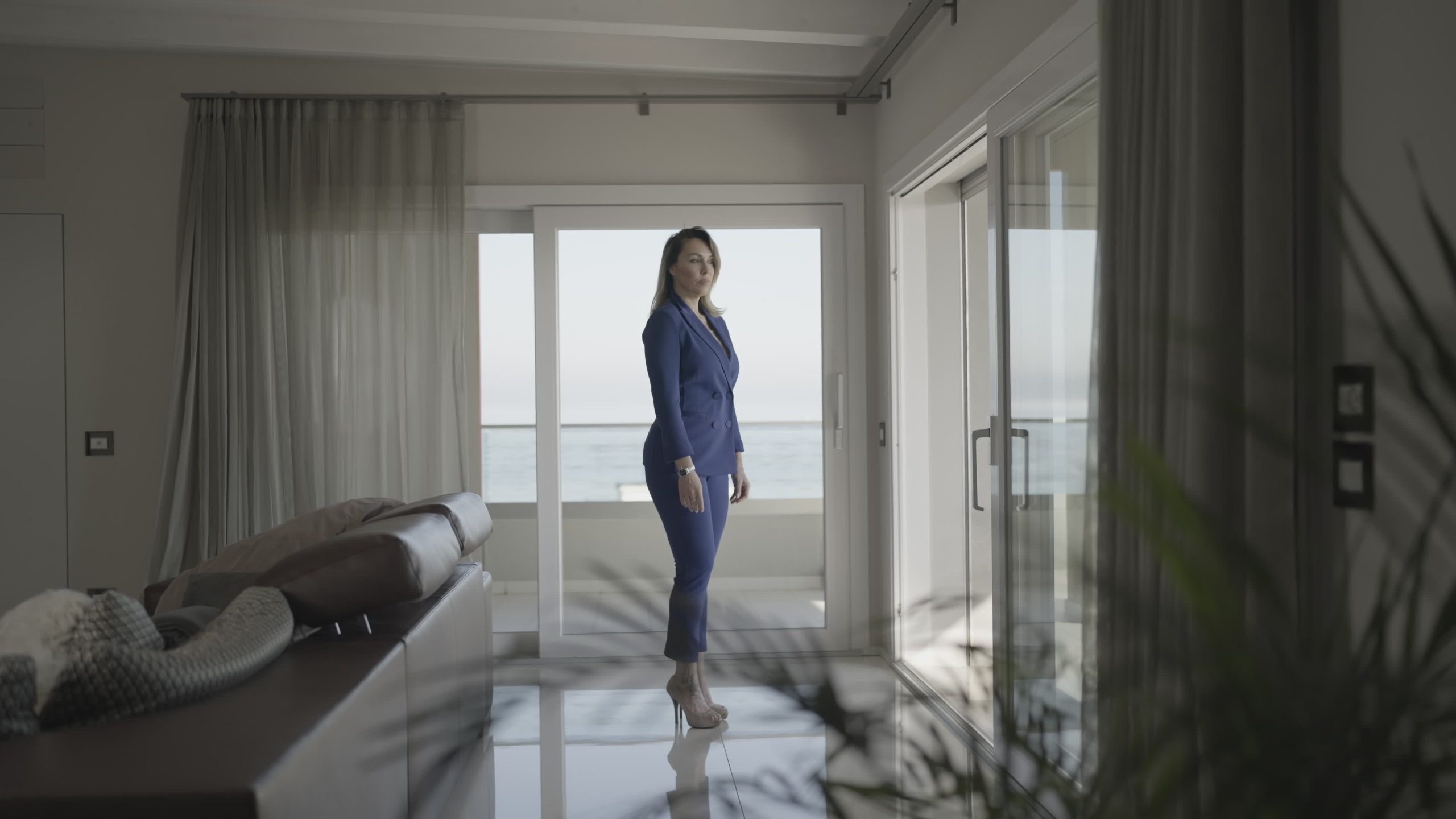 Serious woman with heels looks in the window at home