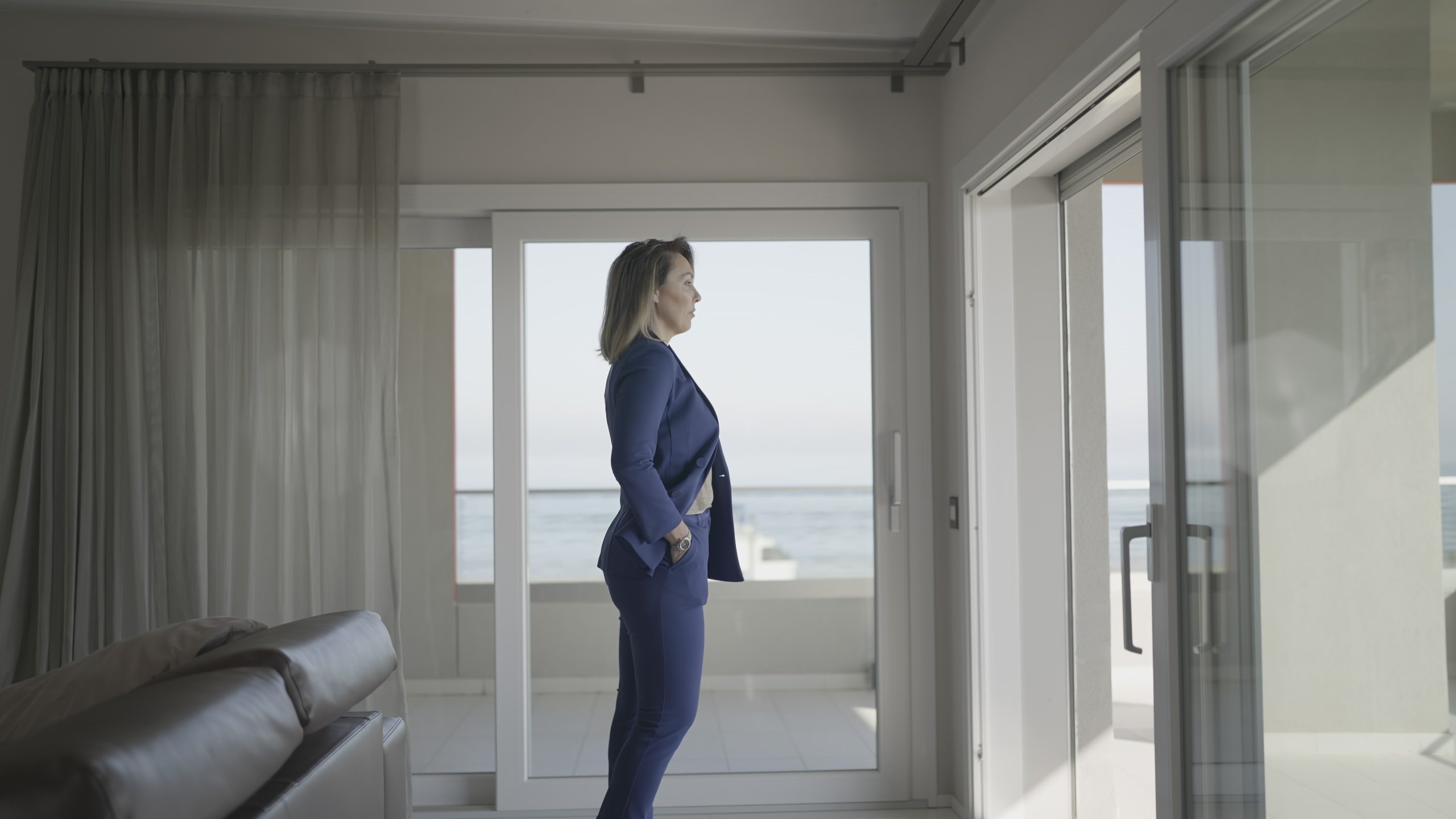 Serious dressed woman looks into office windows