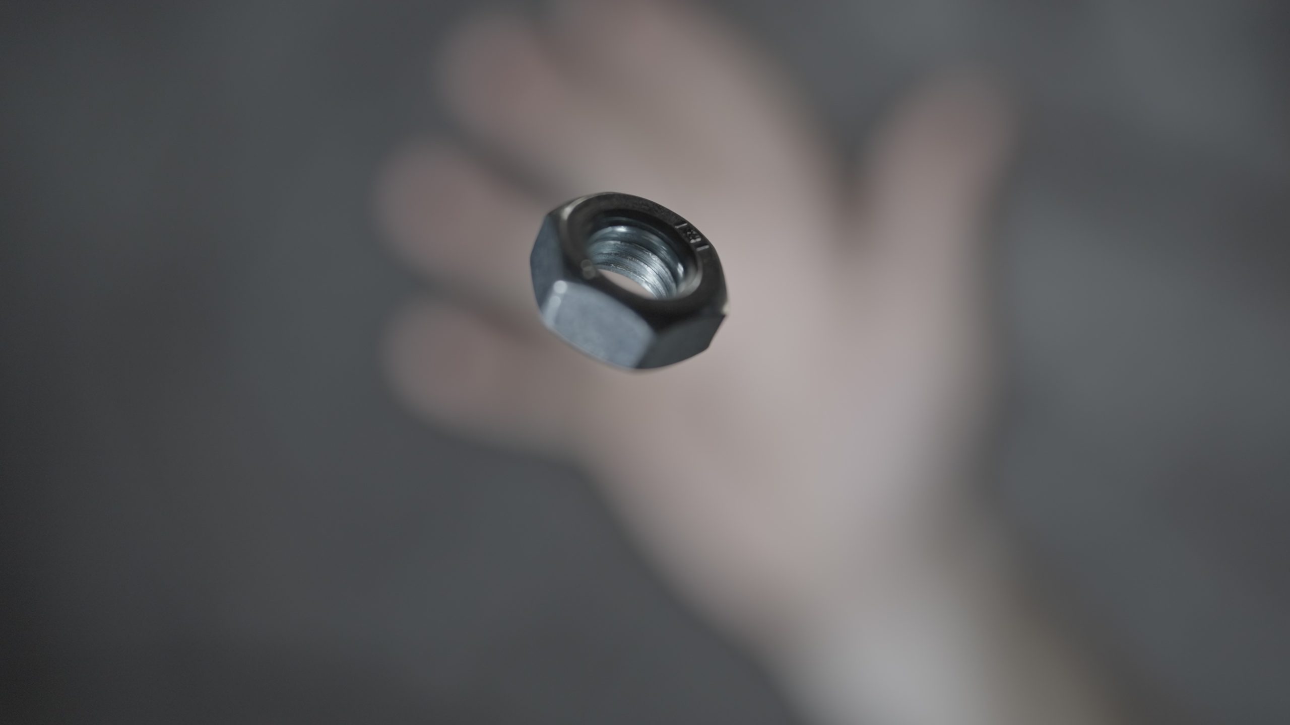 A metal bolt is thrown by hand in slow motion