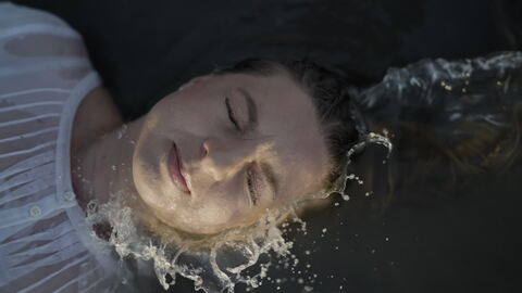 Woman Floating with Eyes Closed in Water