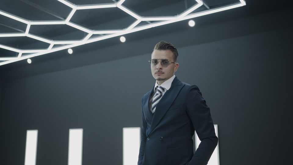 Confident man in suit under geometric lighting